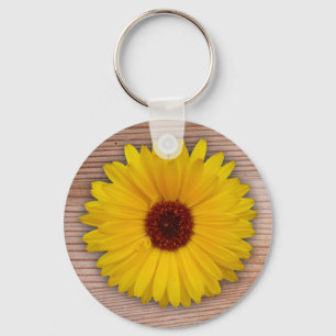 Llavero Marigold de girasol en tablas de madera rusas