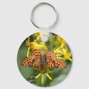 Llavero Mariposa negra y Naranja sobre flores amarillas