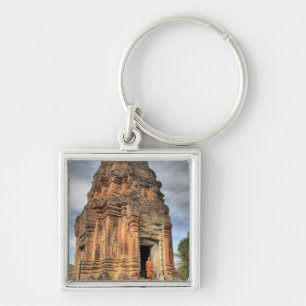 Llavero monje budista de pie en la puerta de un templo