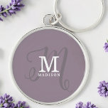 Llavero Monograma de caligrafía estiloso y nombre morado<br><div class="desc">Una hermosa cadena de claves femenina con un elegante nombre y monograma con serios clásicos y una caligrafía de escritura más ornamentada en un diseño equilibrado y hermoso. Los tres elementos se mezclan con una sofisticada armonía y crean su propio logotipo de marca personal. Se muestra aquí con un fondo...</div>