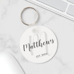 Llavero Monograma personalizado de guión moderno y nombre<br><div class="desc">Regalo de Monograma y Nombre Familiar personalizado con nombre familiar en estilo de letra de escritura moderno gris y monograma en estilo de letra de escritura moderno gris claro como fondo con año establecido en sans grises serif estilo de fuente sobre fondo blanco. Perfecto como regalo para recién casados, regalo...</div>