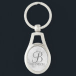 Llavero Monograma y nombre personalizados en escritura de<br><div class="desc">Regalo de monograma y nombre personalizado con monograma personalizado en estilo de letra script clásico gris y nombre en estilo de letra serif clásico gris sobre fondo de mármol blanco. Perfecto para vacaciones, reunión familiar y cualquier ocasión especial. Tenga en cuenta: los detalles de mármol son simulados en la obra...</div>