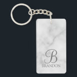 Llavero Monograma y nombre personalizados en guión de márm<br><div class="desc">Regalo de monograma y nombre personalizados con monograma personalizado en estilo de fuente clásica gris y nombre en estilo de fuente serif clásica gris sobre fondo de mármol blanco. Perfecto para vacaciones, reuniones familiares y cualquier ocasión especial. Tenga en cuenta: los detalles de mármol son simulados en la obra de...</div>
