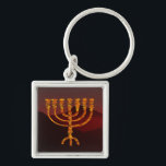 Llavero Moshe es Menorah<br><div class="desc">En la Torá Moshe Rabbenu se le dice: "Harás una Menora de oro puro, golpeada, la Menora será hecha, su base, su rama, sus goballes, sus pechos y sus flores serán martilladas de ella", y más tarde, "Mira, y construye, según su forma que te enseñan en la montaña". 25:40]. Rashi...</div>