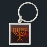 Llavero Moshe es Menorah<br><div class="desc">En la Torá Moshe Rabbenu se le dice: "Harás una Menora de oro puro, golpeada, la Menora será hecha, su base, su rama, sus goballes, sus pechos y sus flores serán martilladas de ella", y más tarde, "Mira, y construye, según su forma que te enseñan en la montaña". 25:40]. Rashi...</div>