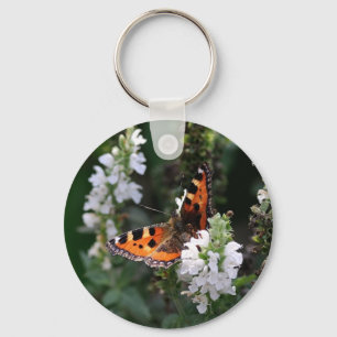 Llavero Naranja y mariposa negra en las flores blancas