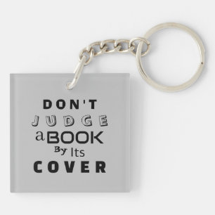 Llavero "No juzgues un libro por su cubierta" gris claro
