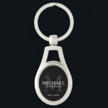 Llavero Nombre y monograma de los groomsmen personalizados<br><div class="desc">Añada un toque personal a su boda con la cadena de teclas personalizada para los groomsmen. Esta cadena de teclas presenta el nombre personalizado del groomsman con título y fecha boda en blanco y monograma en gris como fondo, en estilo clásico de tipo de letra serif, sobre fondo negro. También...</div>
