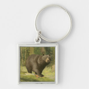 Llavero Oso negro pisando un tronco de árbol