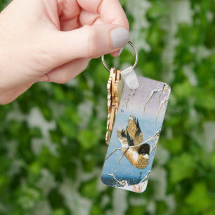 Llavero Pato salvaje nadando entre juncos cargados de niev