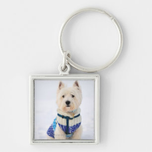 Llavero Perro blanco en ropa en la nieve