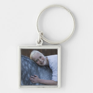 Llavero retrato de la chica joven en el caballo blanco