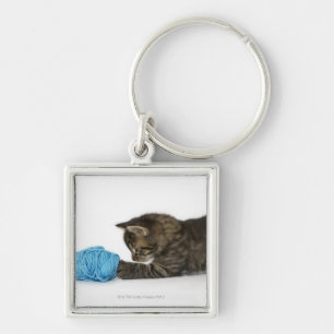 Llavero Un gatito joven del Tabby que juega con lanas