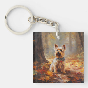 Llavero Yorkshire Terrier en otoño inspira caída de hojas