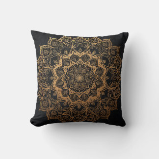 Mandala dorada sobre almohada negra