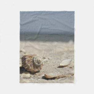 Manta Polar Seashells en la arena por el mar