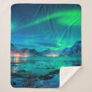 Manta Sherpa Aurora borealis over the sea coast, snowy mountain
