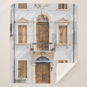 MANTA SHERPA EDIFICIO DE CONCRETO BLANCO CON PUERTAS DE MADERA