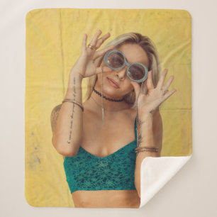 Manta Sherpa Mujer con morena azul sosteniendo gafas de sol pon