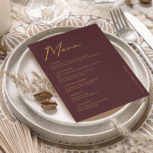 Menú de mesa de boda con tipografía dorada y burgu
