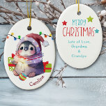 Merry Penguin Niños Navidades Ornamento cerámico<br><div class="desc">En la parte delantera de este adorno cerámico para un niño hay un adorable pingüino con sombrero de Santa y bufanda de invierno. El pingüino tiene una bombilla de árbol de Navidad entre sus pies, y paquetes de regalo a su lado. Hay una cadena de luces navideñas detrás. El nombre...</div>