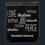 Mochila Hanukkah hebreo negro<br><div class="desc">Elegante bolsa de hilo de HANUKKAH con LOVE JOY PEACE, incluyendo traducciones en hebreo en tipografía negra con un RICO fondo NEGRO. El texto es PERSONALIZABLE, en funda se desea cambiar cualquier cosa. FELIZ HANUKKAH también es personalizable, así que puedes reemplazarlo con un nombre o iniciales. Parte de la colección...</div>