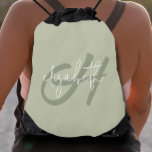 Mochila Monograma moderno<br><div class="desc">Este bolso femenino y liviano de cuerda de inflexión presenta un primer monograma verde y su nombre en blanco sobre un fondo verde sabio. Diversión para ti o como regalo. (Fabuloso para ir de compras)</div>