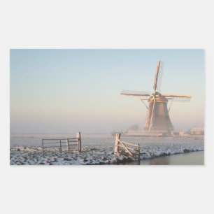 Molino de viento en la nieve en el pegatina del