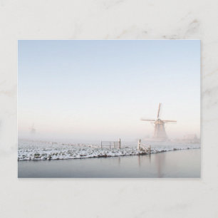 Molino de viento en la nieve en postal de invierno
