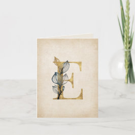 Monograma E dorado y negro con hojas