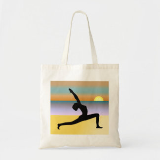 Mujer de yoga en la playa posando una bolsa con pr