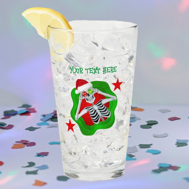Navidades tontos esqueletones ornamentos en bandej (Silly skeleton ornament eyes splatter shape red stars on Merry Christmas glass drink tumbler.)