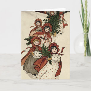 Niñas pequeñas con Holly y el árbol de Navidad