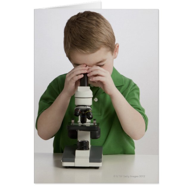 Niño caucásico mirando al microscopio (Frente)
