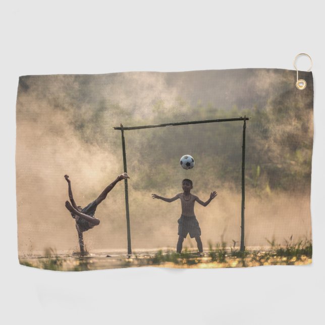 Niño pateando un fútbol en el agua Toallas (Horizontal)