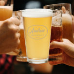 Nombre de Groomsman Boda con estilo de Khaki<br><div class="desc">Vidrio de cerveza para el boda que muestra su nombre impreso en un moderno color caqui, guión estilizado dentro de un borde oval color caqui junto con fecha boda. ¡Una gran idea de fiesta para una fiesta de solteros! Personalice su vaso de cerveza editando y reemplazando el nombre y la...</div>