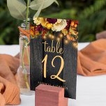 Número de mesa de boda de madera rústica otoño<br><div class="desc">Elegante número de tabla de bodas rústica con texto editable que incluye botánicos caídos y un guión de moda en un fondo de madera marrón oscura con luces de cuerda. Ideal para su verano o otoño en el jardín al aire libre o boda de una casa de campo.</div>
