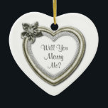 Ornamento de compromiso de corazón de cerámica bla<br><div class="desc">Sorpréndala y emociona con esta hermosa proposición matrimonial en forma de corazón blanco que surge la pregunta "¿Te casarás conmigo?" Diseñado con una falsa imagen cardíaca de color plata y diamante con fondo blanco. La parte posterior tiene un patrón de encaje boda y puede ser personalizada con texto adicional, fecha,...</div>