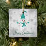 Ornamento verde azulado de cerámica para vacacione<br><div class="desc">Decore su árbol esta temporada de vacaciones con un Verde azulado adorno de cerámica de verano. El diseño de un adorno incluye un bonito muñeco de nieve con un gorra, una bufanda y guantes adornados con copos de nieve grises y blancos sobre un fondo gris. También hay artículos de regalo...</div>