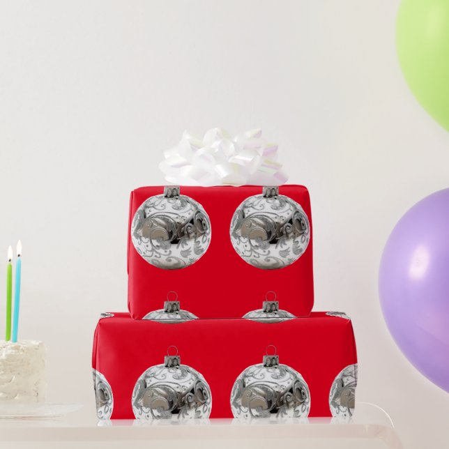 Ornamentos plateados sobre papel de envolver rojo (Regalos de fiesta)