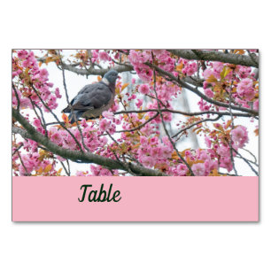 Pájaro colgado en una floreciente tarjeta de mesa 