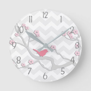 Pájaro gris rosado en el reloj de pared de rama