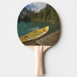 Pala De Ping Pong Canoe estacionado en un muelle a lo largo del lago