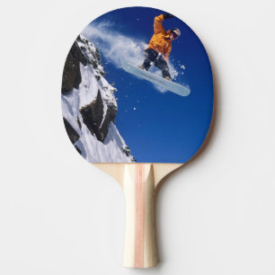 Pala De Ping Pong Hombre en una snowboard saltando de una cornisa en