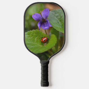 Palas De Pickleball Ladybug sobre las dulces flores violetas
