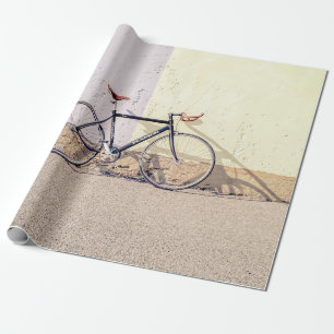 PAPEL DE REGALO BICICLETA NEGRA Y GRIS EN MURO BLANCO