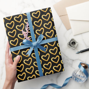 Papel de regalo con corazón dorado sobre fondo neg