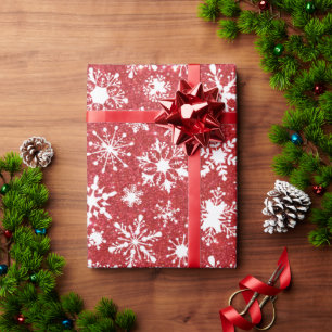 Papel de regalo con purpurina roja y copos de niev