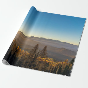 PAPEL DE REGALO PINOS VERDES EN MONTAÑA BAJO CIELO AZUL DURANTE EL