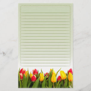 Papelería El tulipán amarillo rojo florece el fondo verde